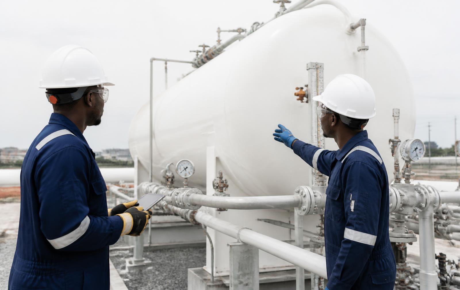 Excello engineers inspecting an aboveground LPG storage tank and pipework